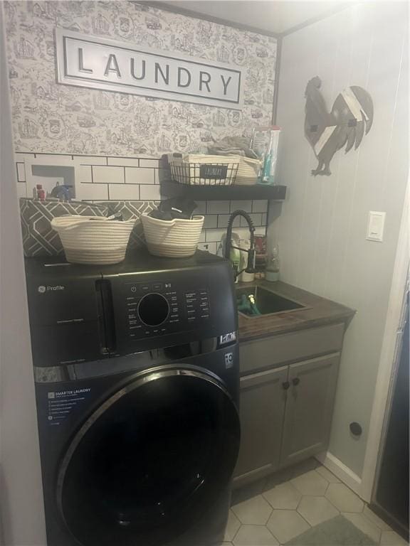 laundry room featuring washer / dryer, cabinets, light tile patterned flooring, and sink