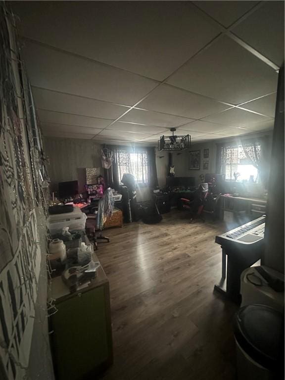 basement featuring a healthy amount of sunlight, a paneled ceiling, and hardwood / wood-style floors