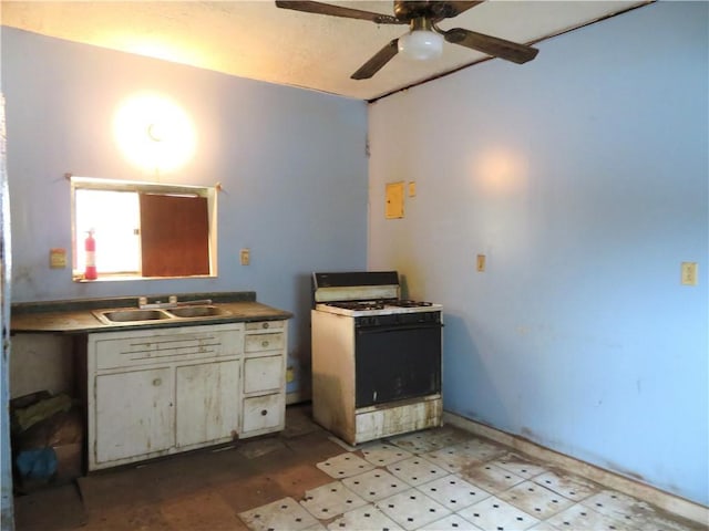 kitchen featuring ceiling fan, white gas range oven, and sink