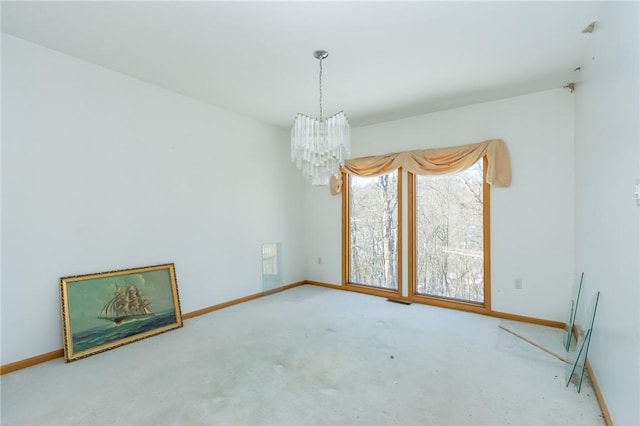 unfurnished room with carpet floors and a chandelier