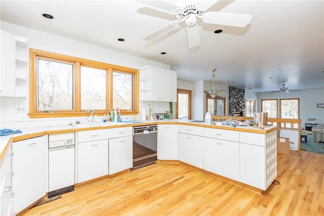 kitchen featuring white cabinets, black dishwasher, and kitchen peninsula