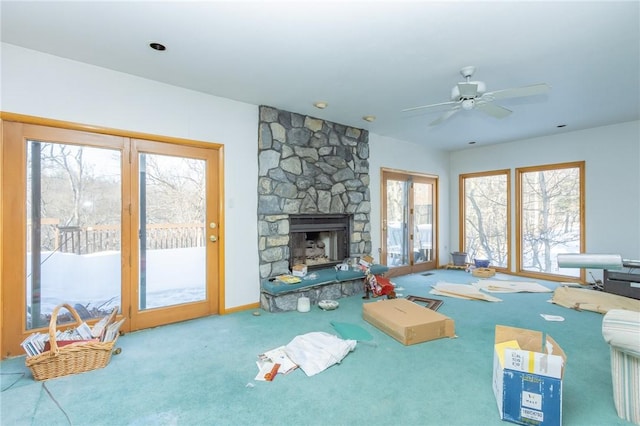 carpeted living room with ceiling fan and a fireplace