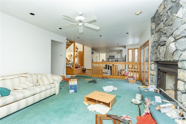 carpeted living room with ceiling fan and a fireplace