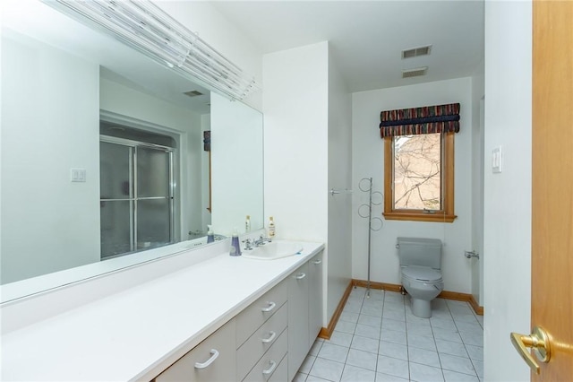 bathroom with a shower with shower door, toilet, vanity, and tile patterned flooring