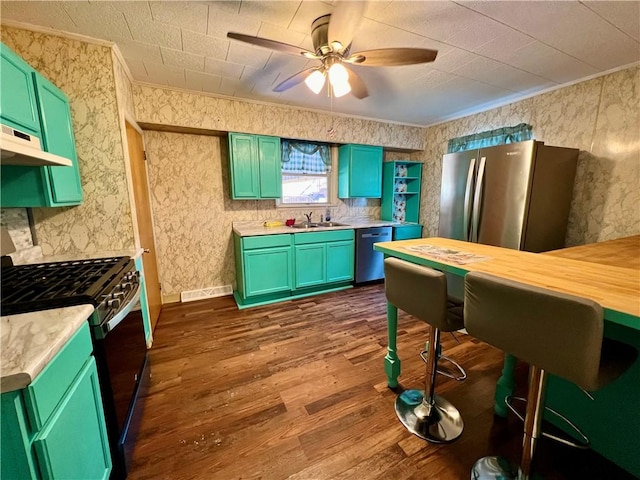 kitchen featuring ceiling fan, dark hardwood / wood-style floors, crown molding, appliances with stainless steel finishes, and wood counters