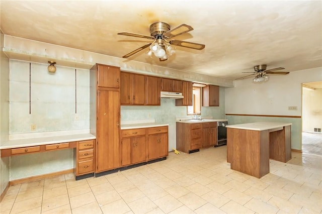 kitchen featuring under cabinet range hood, ceiling fan, brown cabinetry, and black dishwasher