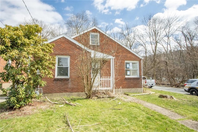 bungalow-style home featuring brick siding and a front lawn