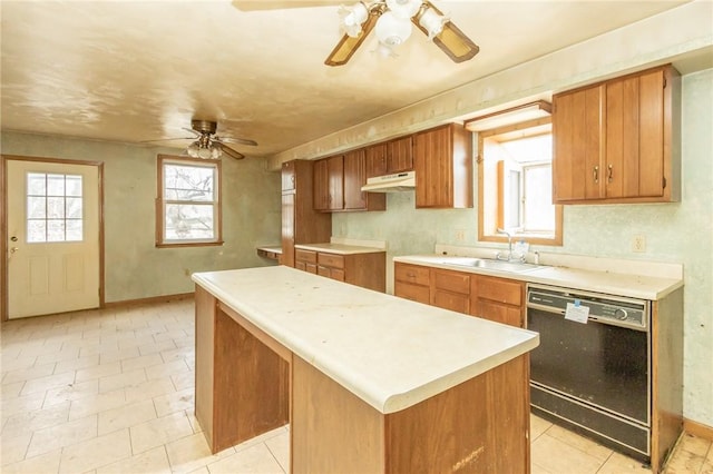 kitchen with black dishwasher, a ceiling fan, under cabinet range hood, a sink, and a center island