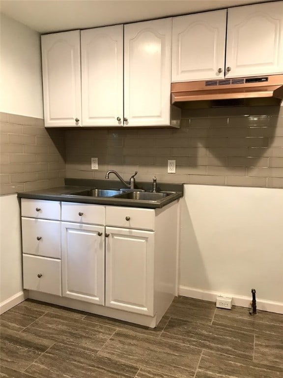 kitchen featuring decorative backsplash, sink, and white cabinetry