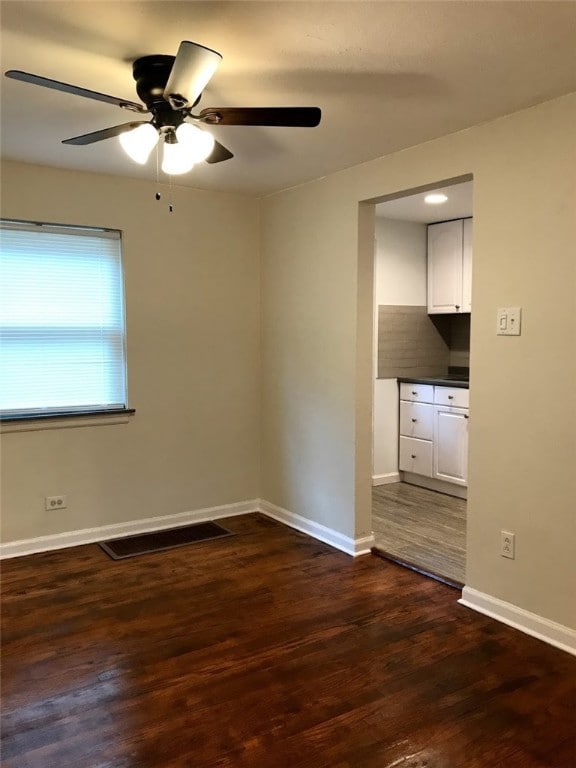 unfurnished room with dark wood-type flooring and ceiling fan