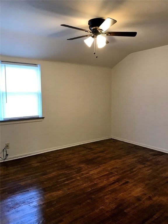 empty room featuring ceiling fan, dark hardwood / wood-style flooring, and vaulted ceiling