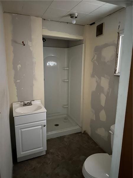 bathroom with walk in shower, vanity, and toilet