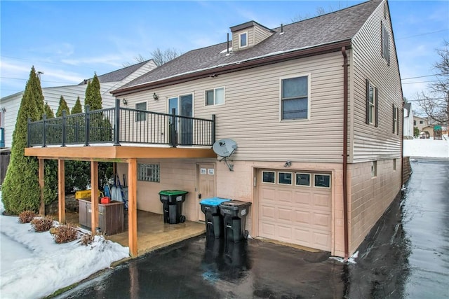 snow covered property with a garage