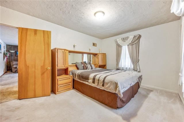 bedroom with light carpet and a textured ceiling