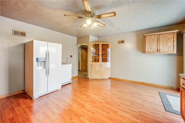 unfurnished living room with a textured ceiling, ceiling fan, and light hardwood / wood-style floors