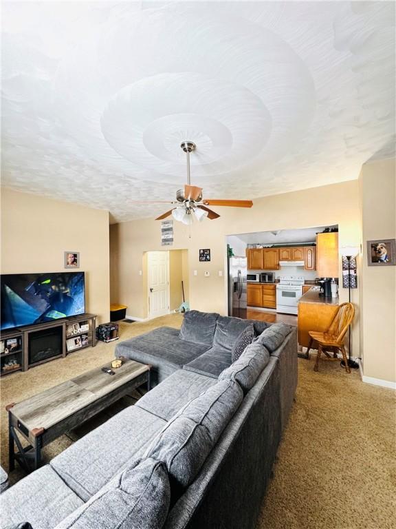 living room featuring vaulted ceiling and ceiling fan