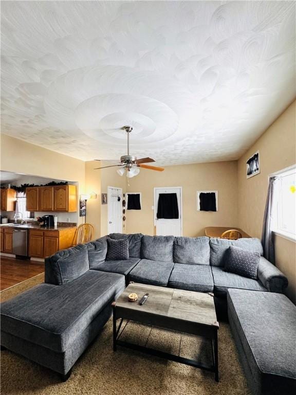 living room featuring ceiling fan and a textured ceiling