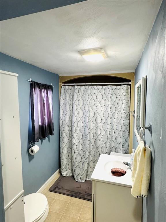 bathroom featuring vanity, tile patterned floors, and toilet