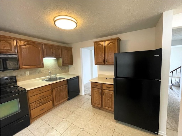 kitchen featuring black appliances, sink, tasteful backsplash, and a textured ceiling