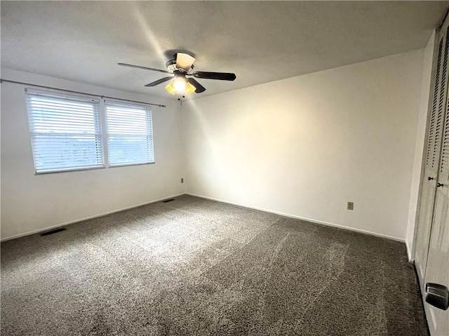 carpeted spare room featuring ceiling fan