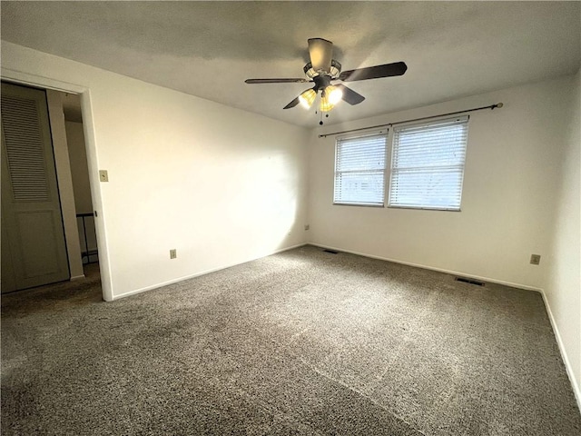 unfurnished room featuring dark colored carpet and ceiling fan