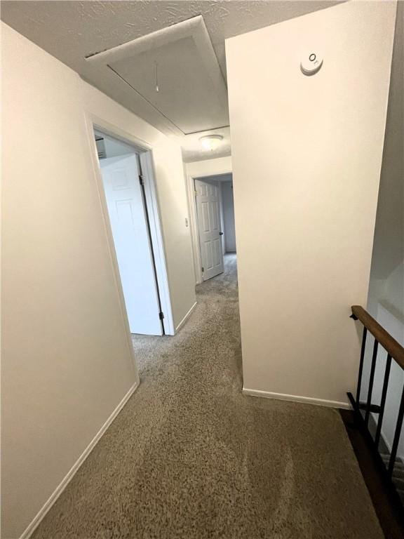 hallway with carpet and a textured ceiling