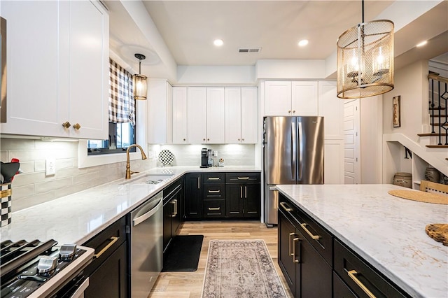 kitchen featuring white cabinetry, appliances with stainless steel finishes, and pendant lighting