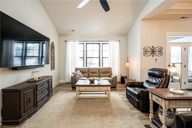 living room featuring lofted ceiling, a wealth of natural light, and light hardwood / wood-style floors