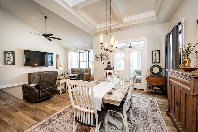 dining space with vaulted ceiling with beams, ceiling fan with notable chandelier, light hardwood / wood-style flooring, and ornamental molding