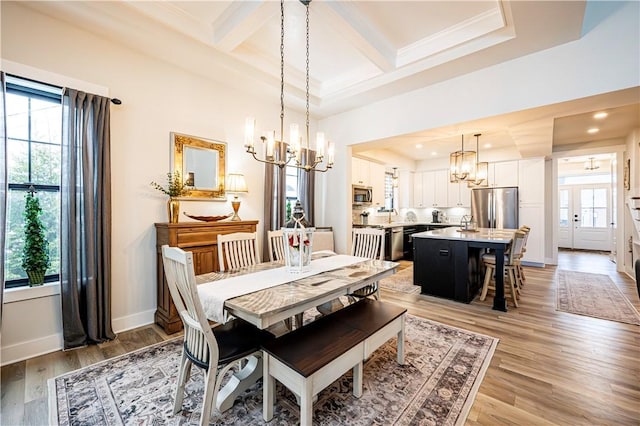 dining area with coffered ceiling, an inviting chandelier, wood-type flooring, ornamental molding, and beamed ceiling