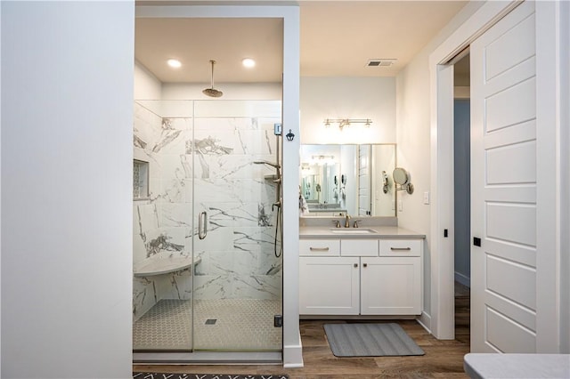 bathroom featuring wood-type flooring, vanity, and walk in shower