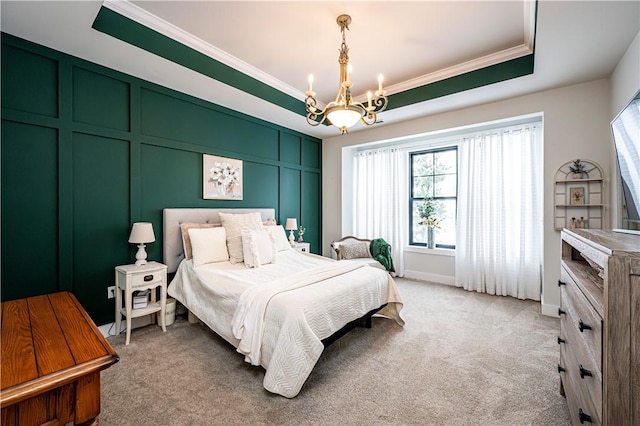 carpeted bedroom featuring ornamental molding, a tray ceiling, and a chandelier