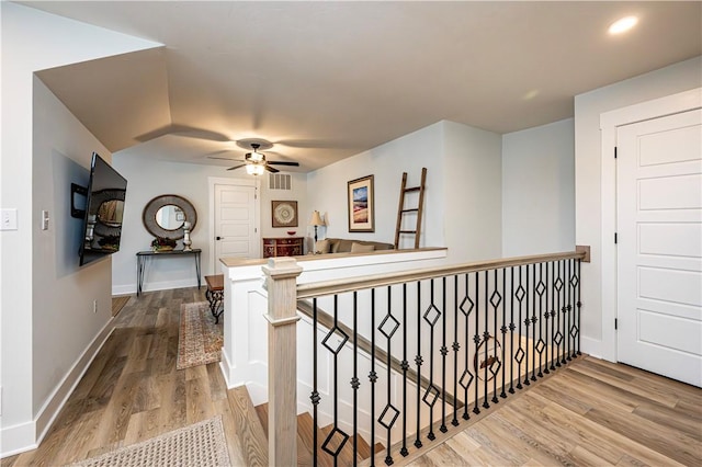 hallway featuring wood finished floors, an upstairs landing, baseboards, visible vents, and recessed lighting
