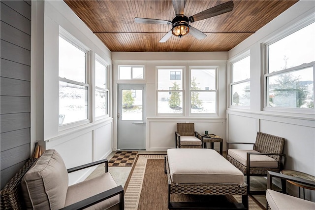 sunroom featuring ceiling fan and wood ceiling