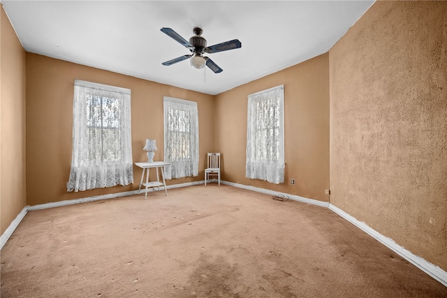 carpeted spare room with ceiling fan