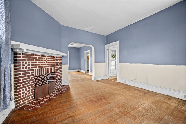 unfurnished living room with a tiled fireplace and hardwood / wood-style flooring