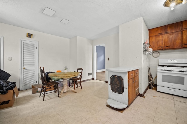 kitchen with white gas range and a textured ceiling