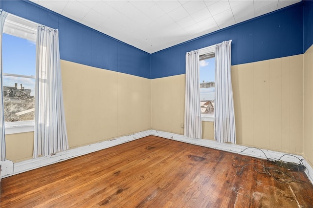 empty room featuring a healthy amount of sunlight and dark wood-type flooring