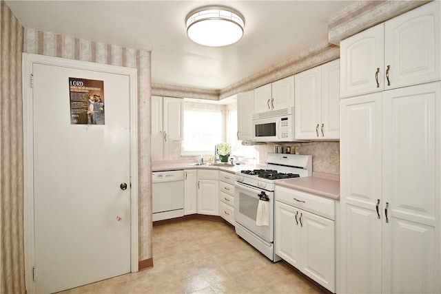 kitchen with sink, white appliances, and white cabinets