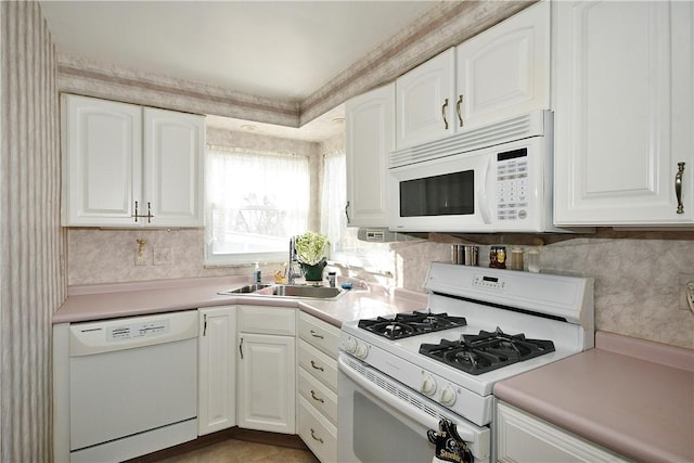 kitchen with white cabinetry, sink, white appliances, and light tile patterned floors