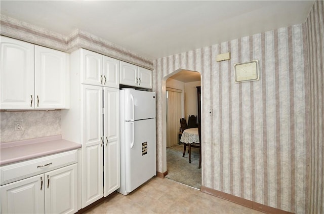 kitchen featuring white cabinets and white refrigerator