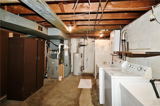 clothes washing area with sink, heating unit, gas water heater, and washing machine and clothes dryer