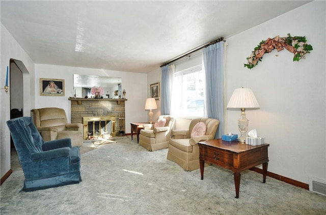 living room featuring a stone fireplace and carpet flooring