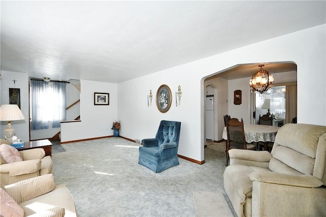 carpeted living room with an inviting chandelier