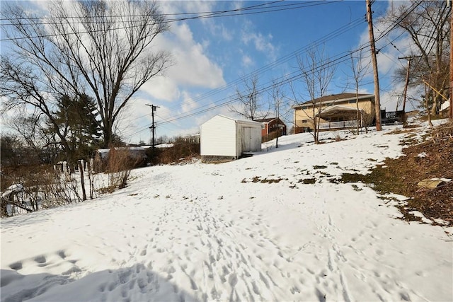 snowy yard featuring a shed