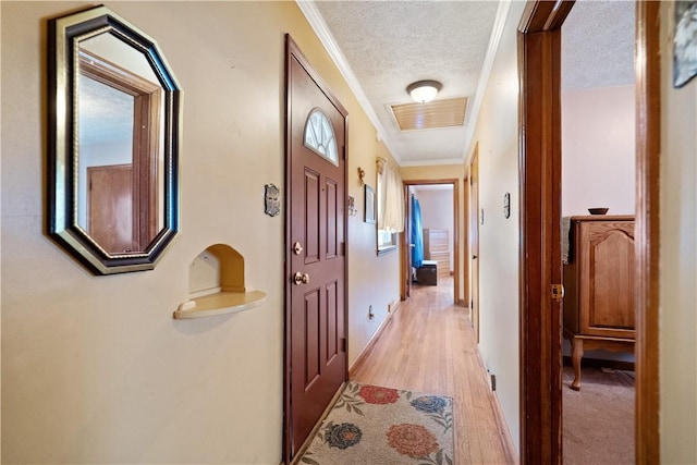 corridor featuring a textured ceiling, crown molding, and light hardwood / wood-style flooring