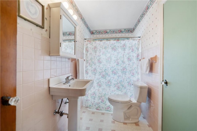 bathroom featuring toilet, tile walls, and a shower with curtain