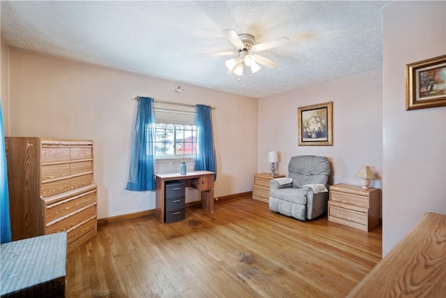 living area with a textured ceiling, ceiling fan, and hardwood / wood-style flooring