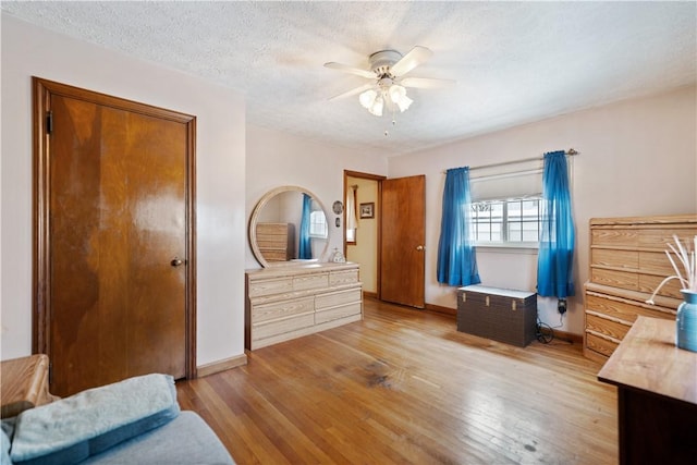 bedroom with ceiling fan, a textured ceiling, and light hardwood / wood-style floors