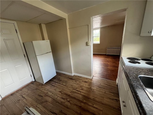 kitchen featuring radiator, dark wood-type flooring, white cabinetry, and white refrigerator